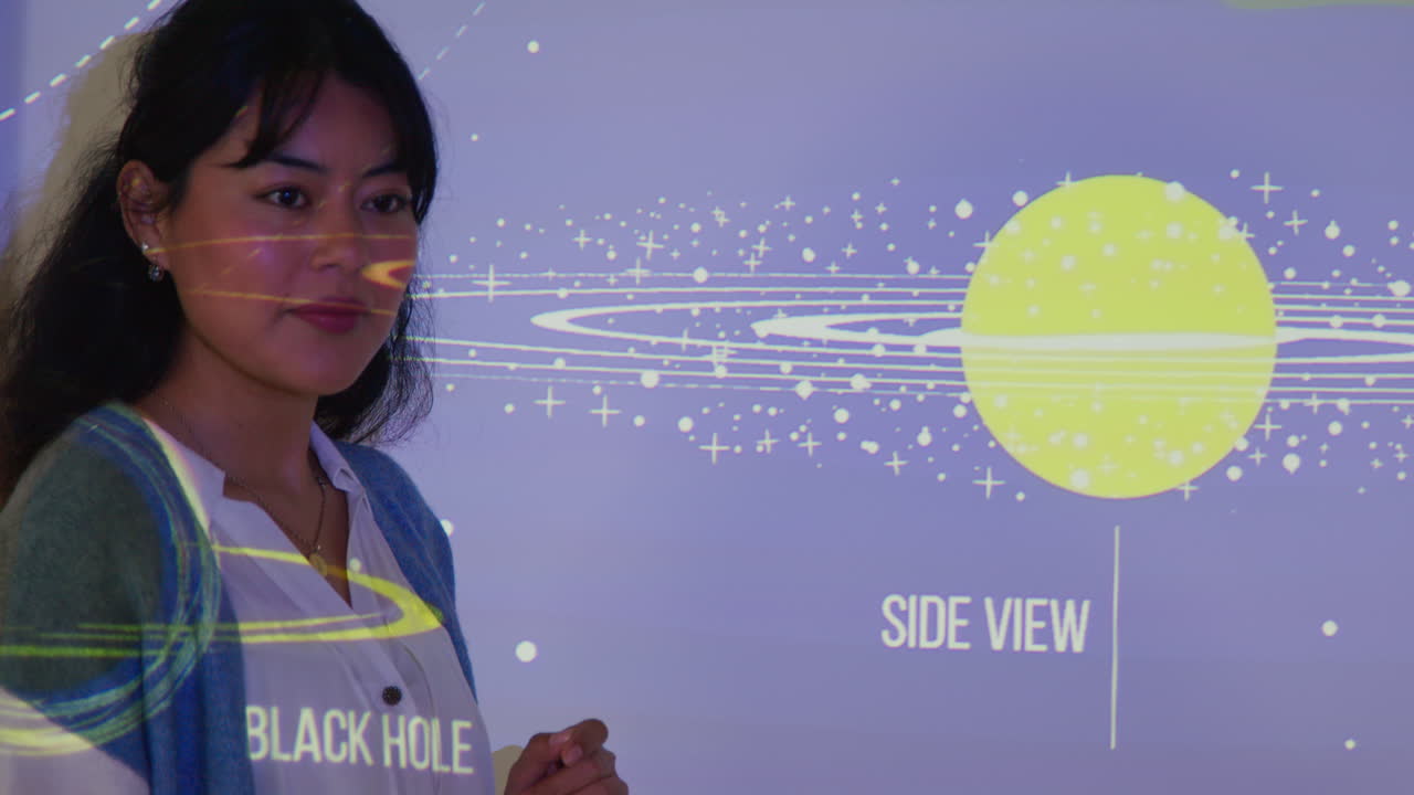 학교에서 천문학 수업을 하는 여자 교사, 태양계 2의 투사와 함께 수업 앞에 서 있습니다.