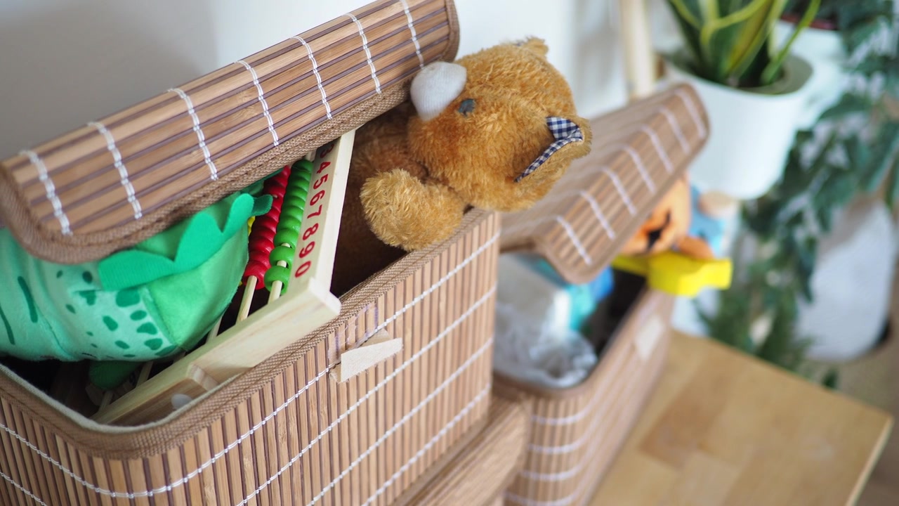 Orsetto di peluche e giocattoli all'interno di cesti portaoggetti in bambù
