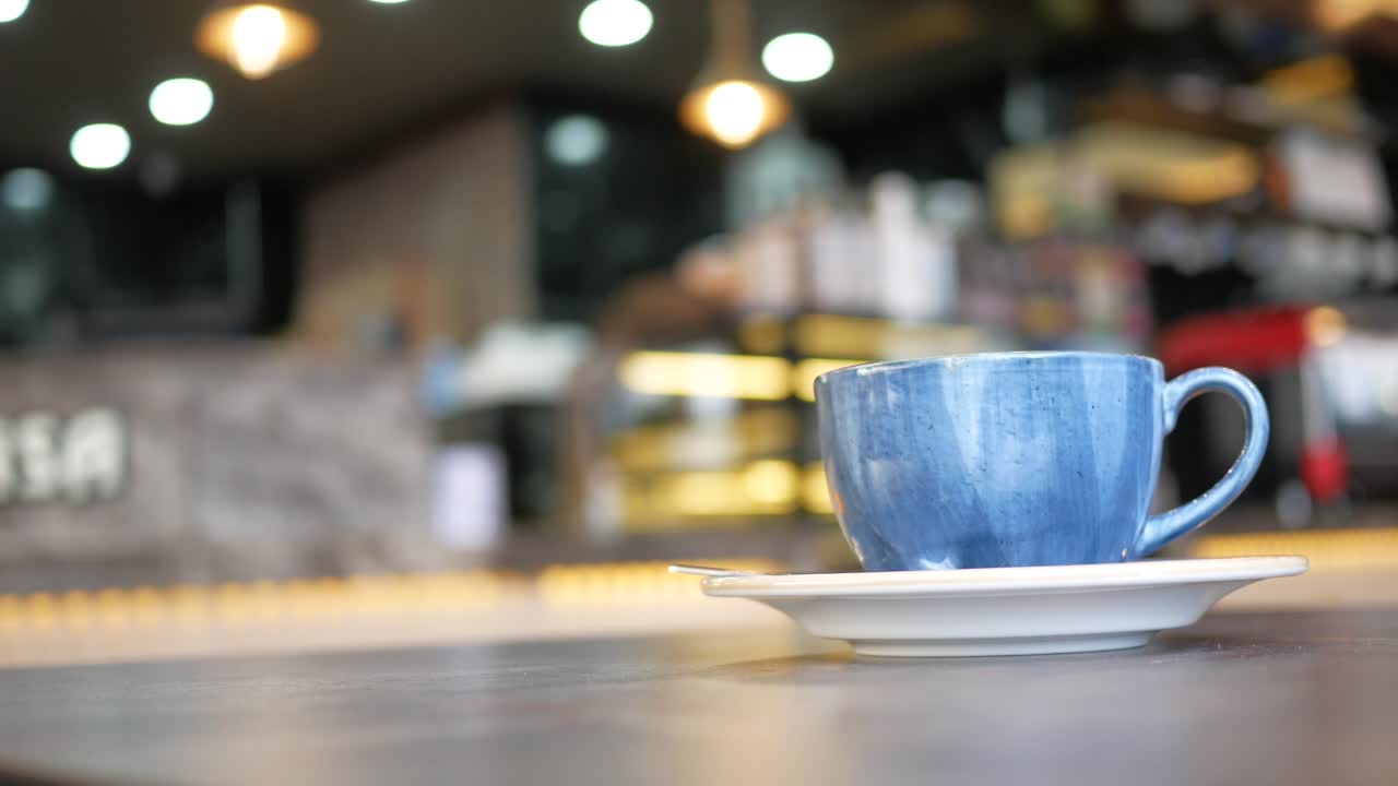 taza de café azul en una mesa en una cafetería
