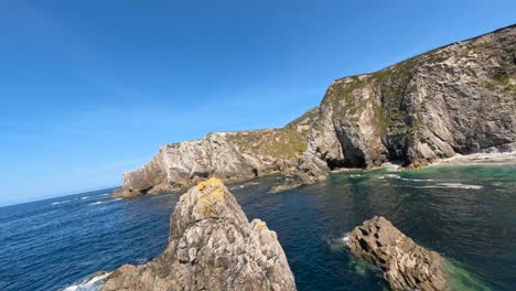 fpv drone flying around a rock in heavenly beach in ireland