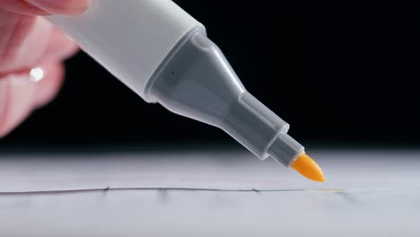 close-up of a hand highlighting text with a yellow marker