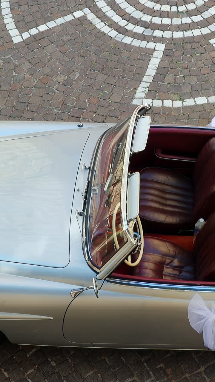 Silver car with burgundy interior on display on the streets of Antibes, France. Vertical