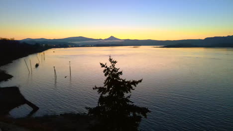 drone staying in place above a beautiful lake during sunrise, making a 180 degree turn, showing a beautiful scenery of the docks