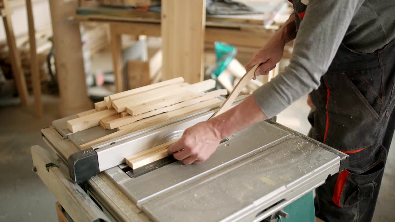 vista de ángulo alto de un fabricante de muebles irreconocible cortando tablas de madera con una sierra circular