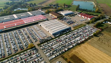 aerial footage of finished cars ready to be shipped on huge distribution center