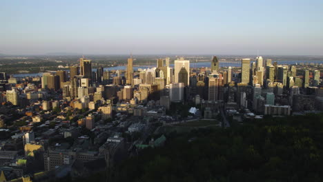 Aerial-view-over-forest-on-Mount-Royal,-toward-the-downtown-of-Montreal,-Canada
