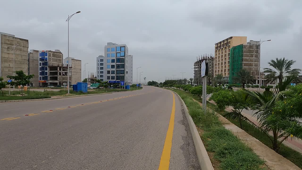 vista a lo largo de la carretera vacía junto a los desarrollos en el desarrollo de viviendas bahria en karachi