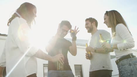 low angle view of joyful friends dancing with beer