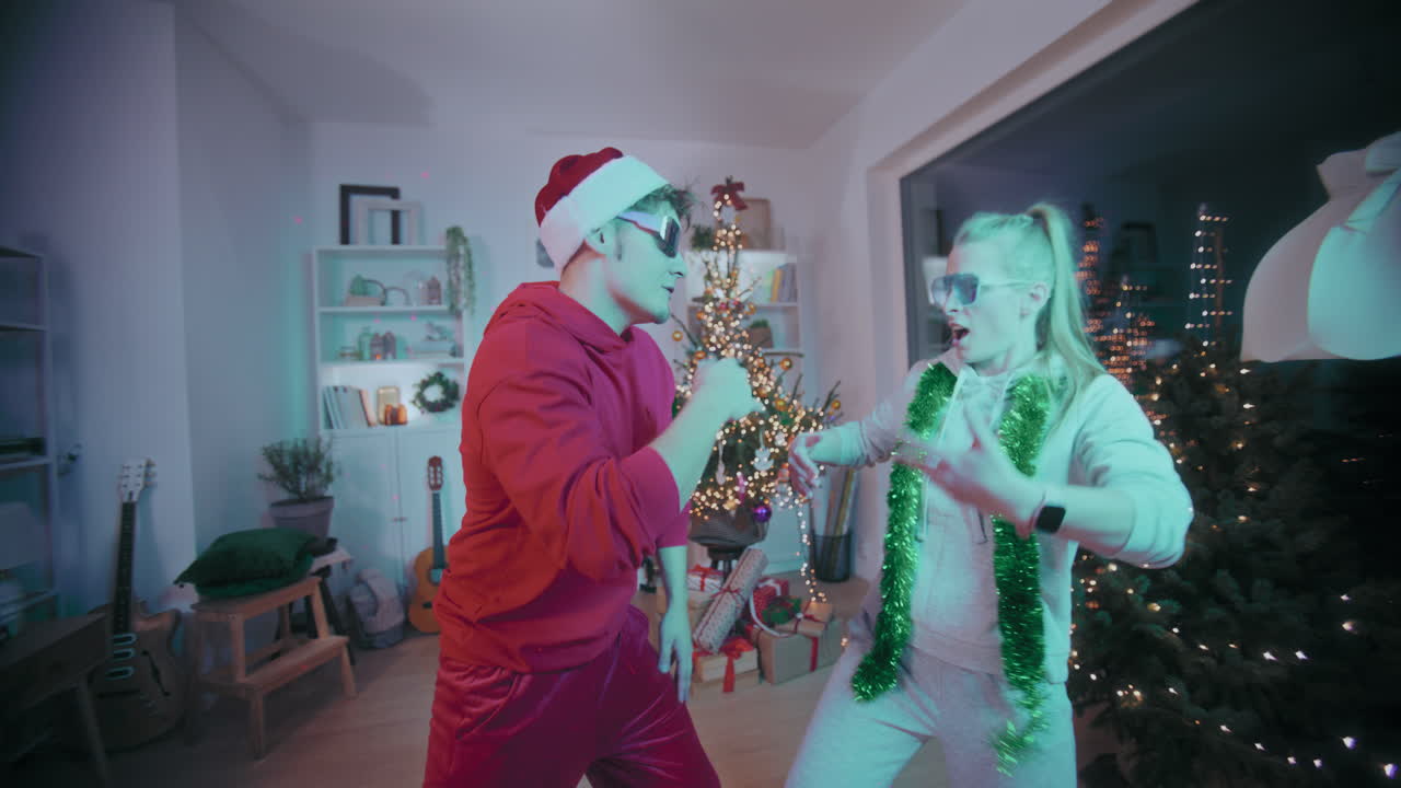 una pareja emocionada bailando en casa durante la navidad.