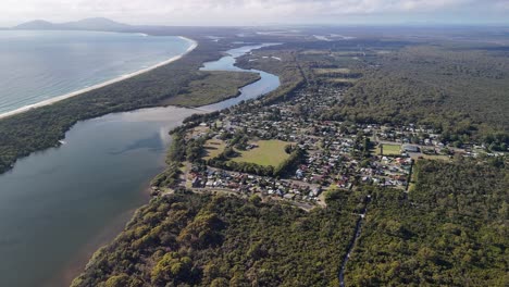 aerial retreats from stuarts point town on nsw ocean coast, australia