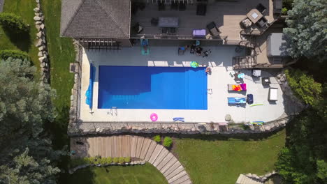 drone shot of a pool with people sitting around it