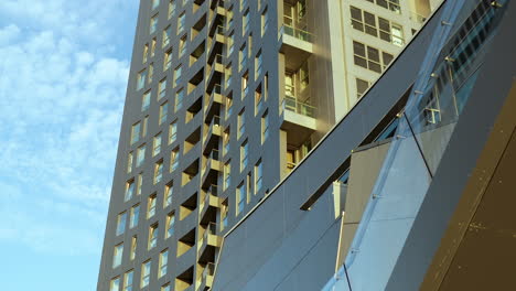 vistazo del horizonte urbano con edificios texturizados y un reflejo del sol en la fachada de vidrio