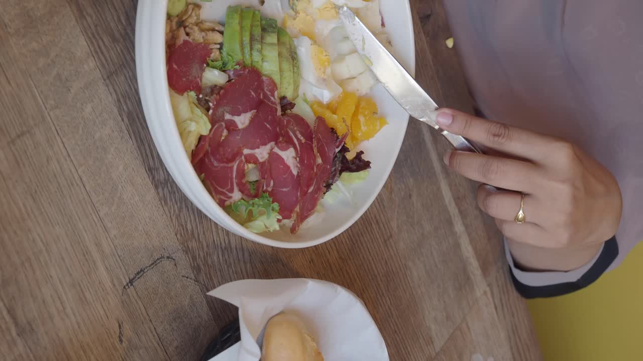 Overhead shot of a salad with meat, eggs, avocado and vegetables