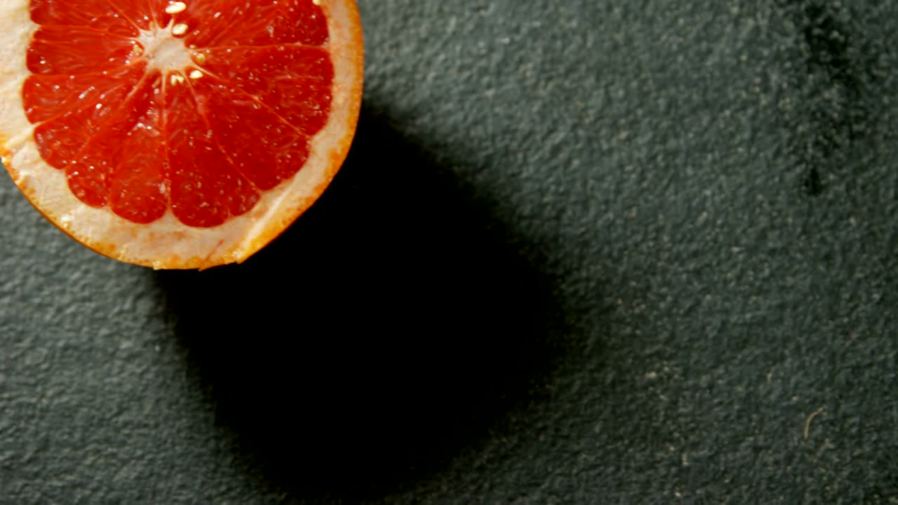 Pompelmo dimezzato su sfondo grigio 4K