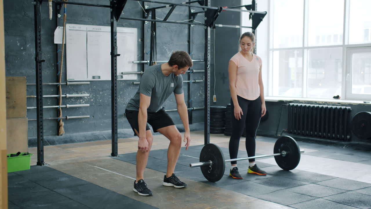 Uomo che solleva pesi con personal trainer
