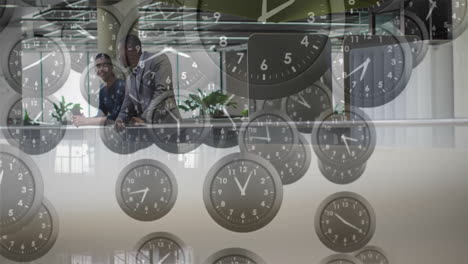 animation of moving clocks over diverse colleagues talking in office