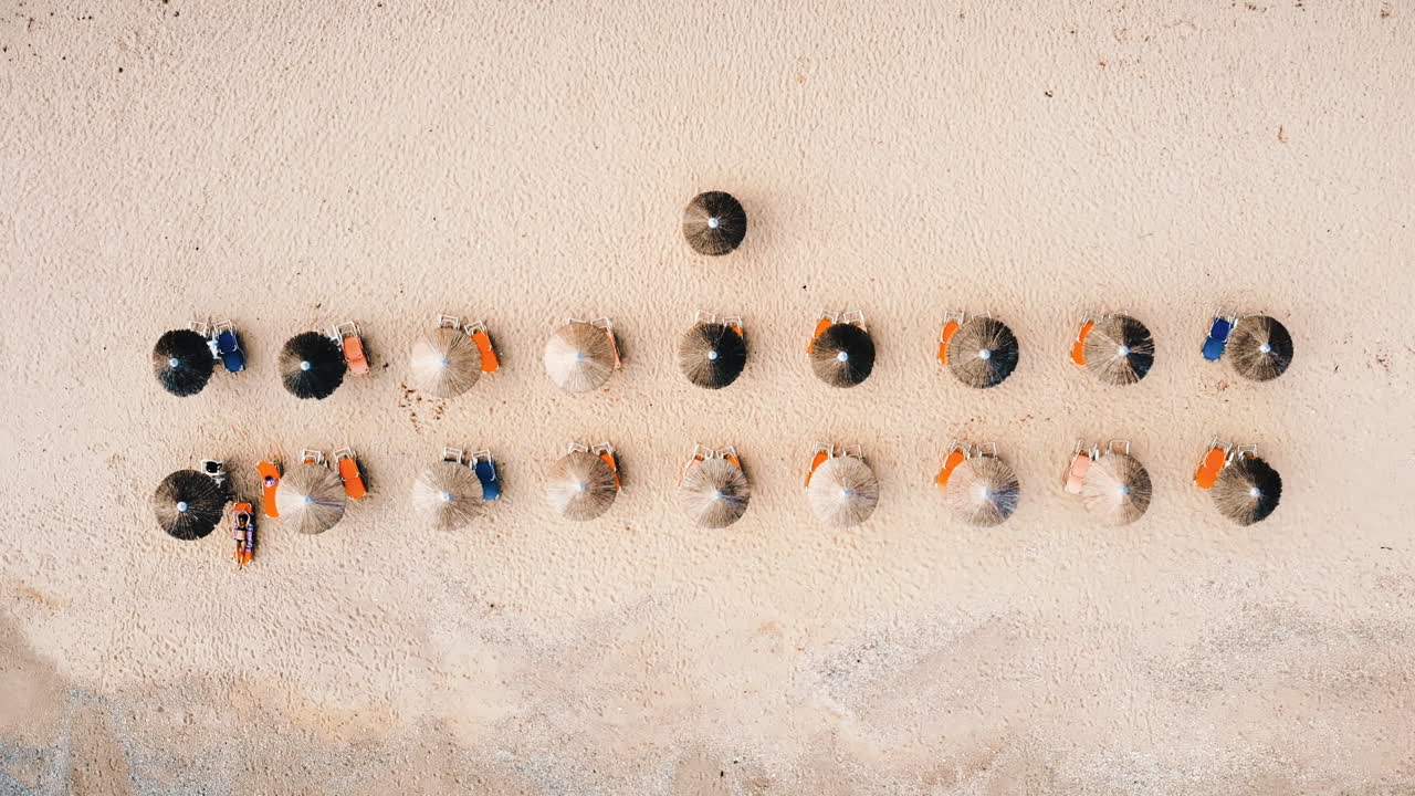 Beach with umbrellas and sunbeds. Foam. Top drone view