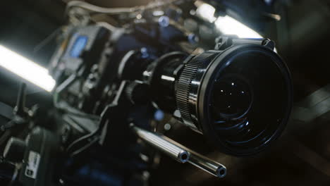 low angle side shot of a professional cinema camera and long telephoto zoom lens, zoom motor is turning the gears and the lens element is moving to change focal length