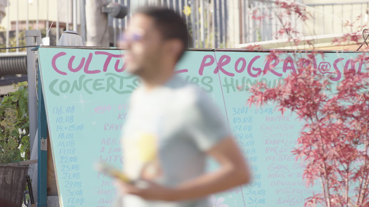 People on the street pass the event calender for Salt, Oslo Fringe
