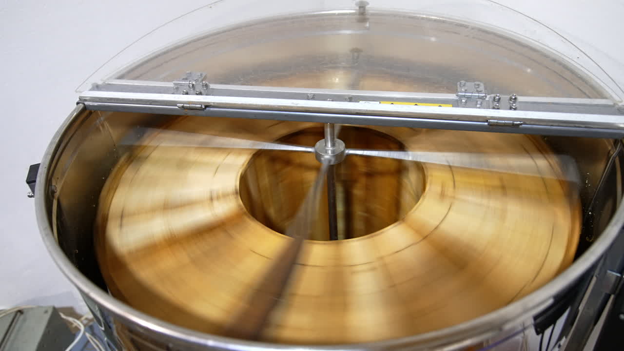 Automatic honey extracting machine rotating many frames at once. Barrel-like apparatus removing honey from honeycombs. Top view.