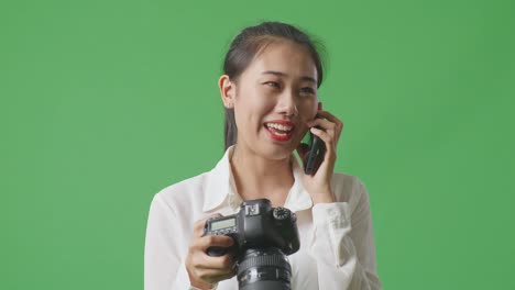 woman holding camera and talking on the phone