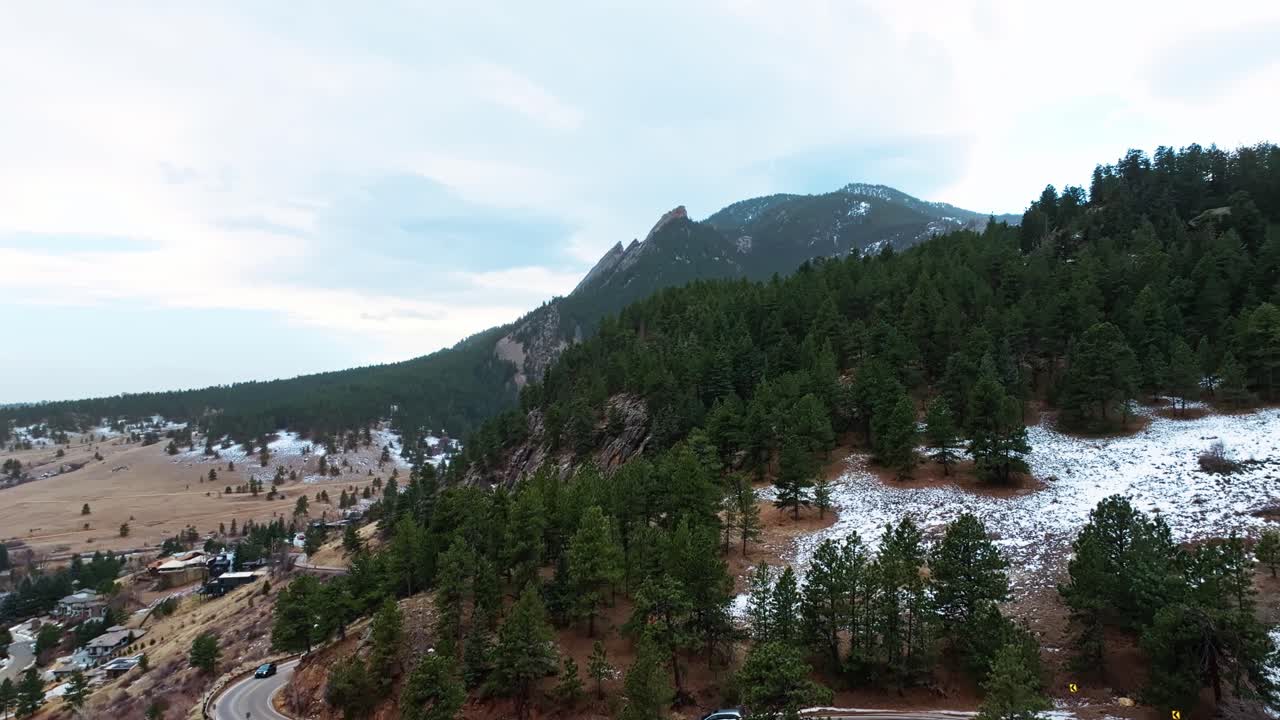 Aerial establishing of Boulder Flatirons landscape under soft light, with dramatic rock formations