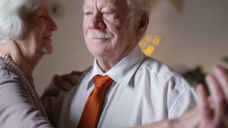 Portrait-Of-A-Loving-Senior-Couple-Dancing-Togheter-At-Home-On-Christmas