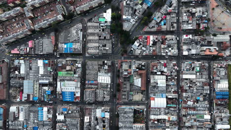 Top-down-drone-shot-rising-above-the-streets-of-Bogota-city,-daytime-in-Colombia