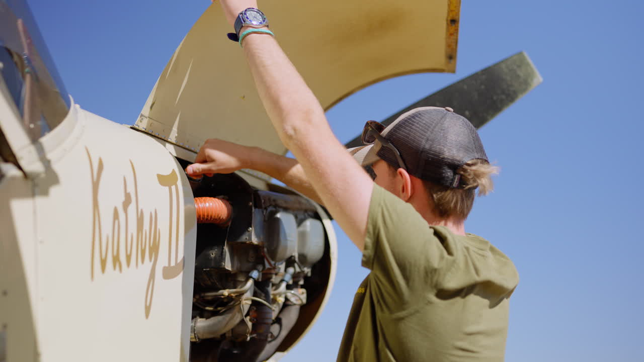 Man Performing Pre-Flight Inspection on Small Airplane Engine