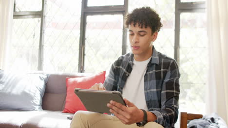 Biracial-man-working-from-home-using-tablet,-slow-motion