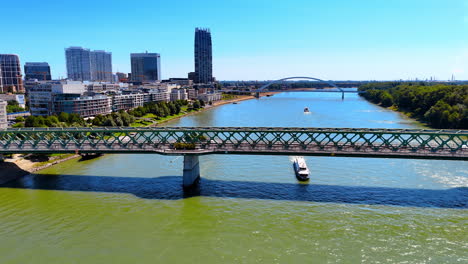 descending over the waterscape of the danube river flowing in bratislava, slovakia. view on the boats moving by the river and bridges crossing it.