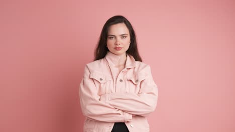 serious young woman thinking in pink studio