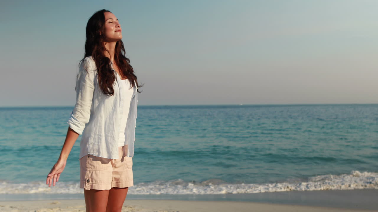 해변에 팔을 은 행복한 여자