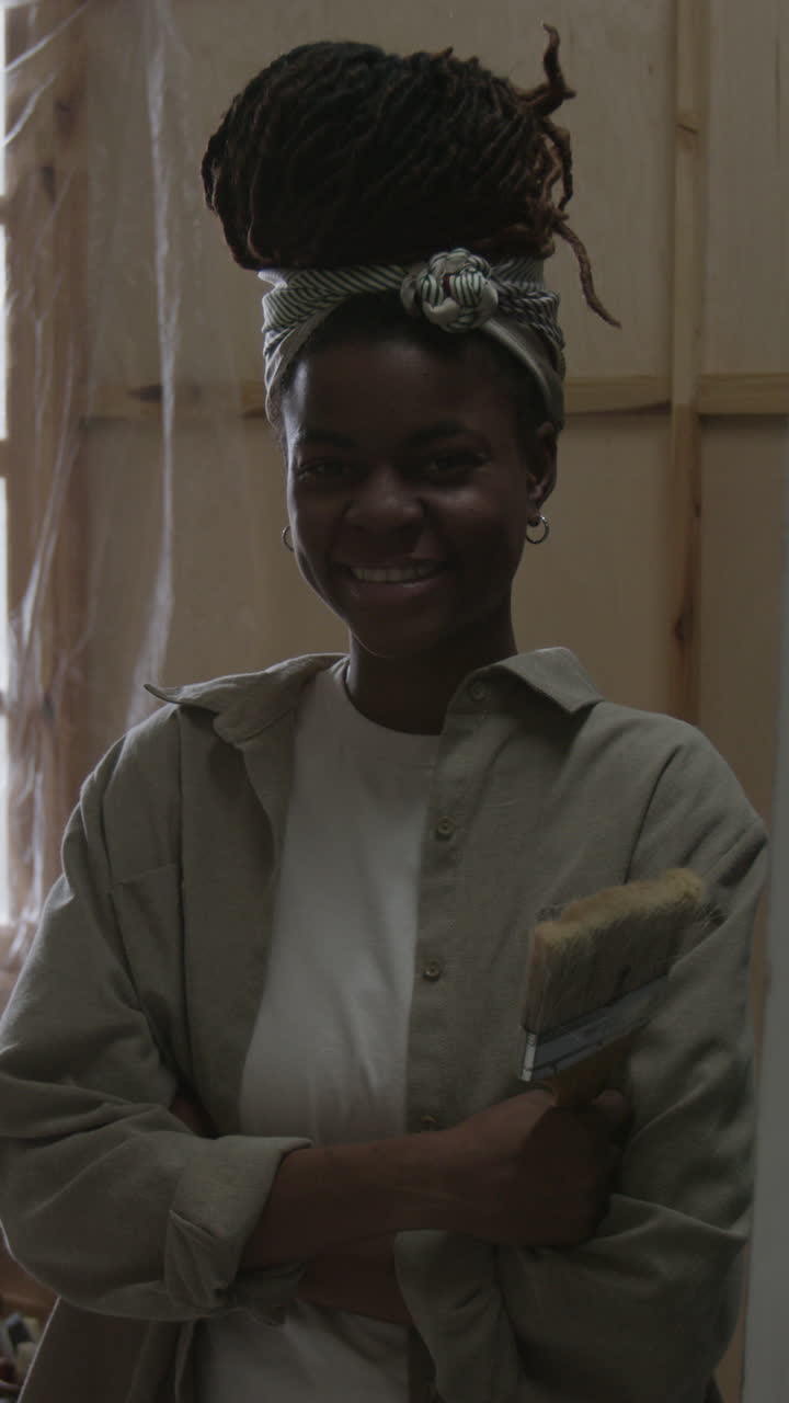 Portrait of a smiling female artist holding a paint brush