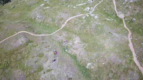 top drone aerial view of hiking path in swiss alps grassery meadows, mountain natural landscape