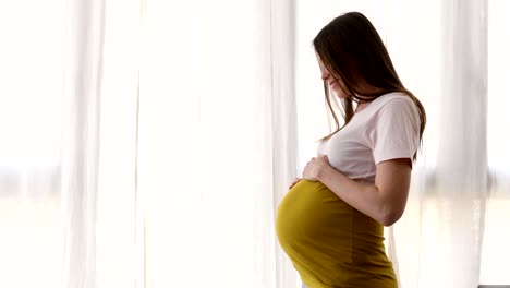 mujer alegre acariciando el vientre en expectativa