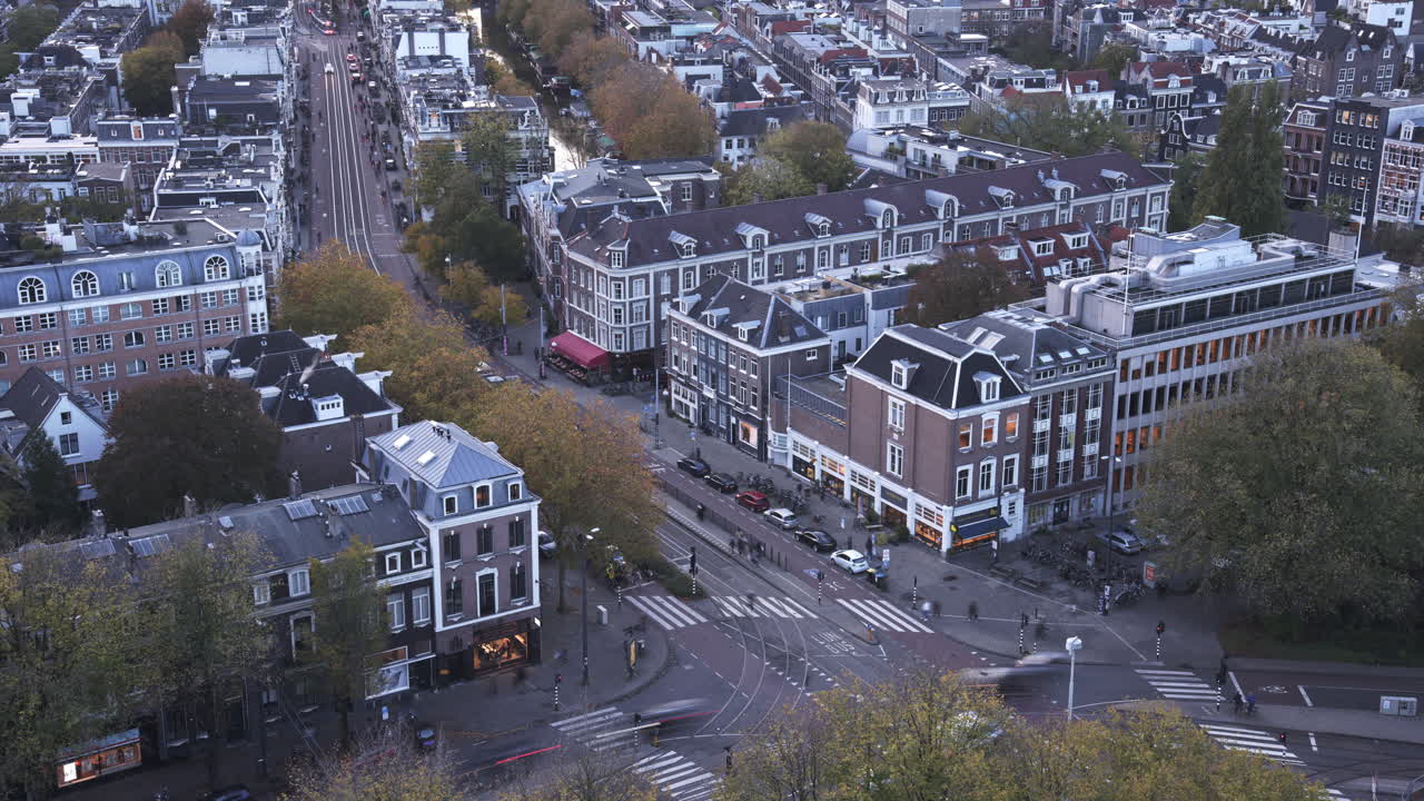 Aerial timelapse of Amsterdam showing busy streets, trams, cars, and classic Dutch buildings at sunset