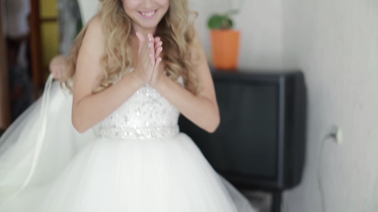 Preparing Bride For The Wedding Day. Bridesmaid helps fasten a wedding dress the bride before the ceremony