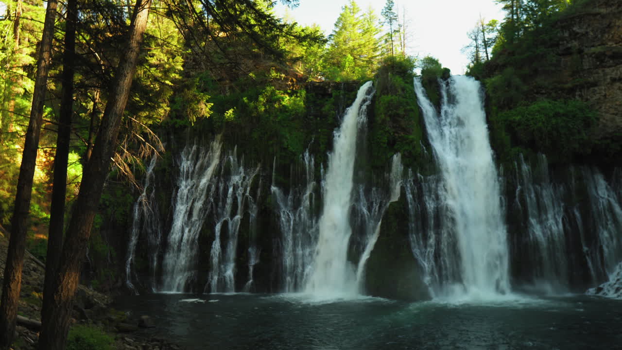 Vista panoramica delle cascate Burney, cascata nel bosco in California, con l'acqua che scende da una scogliera.