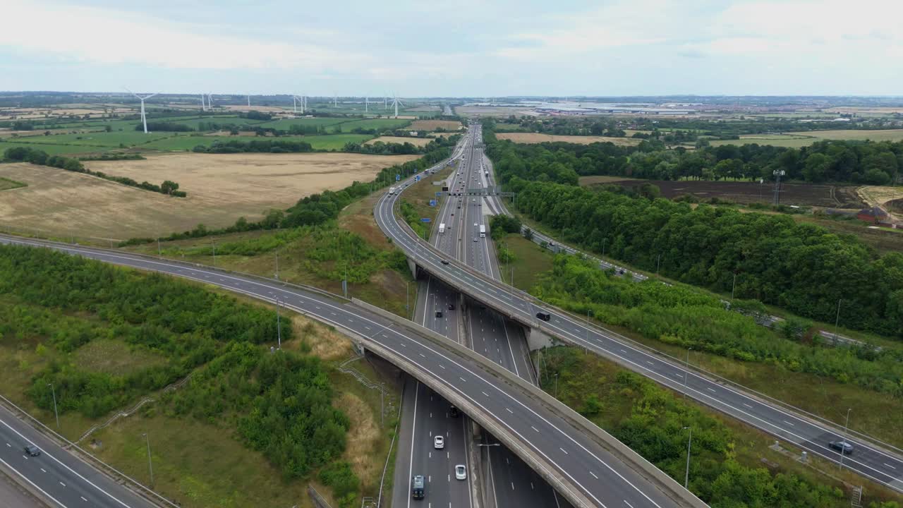 High aerial drone footage of highway intersection and motorway junctions with multiple lanes and crossovers in England UK