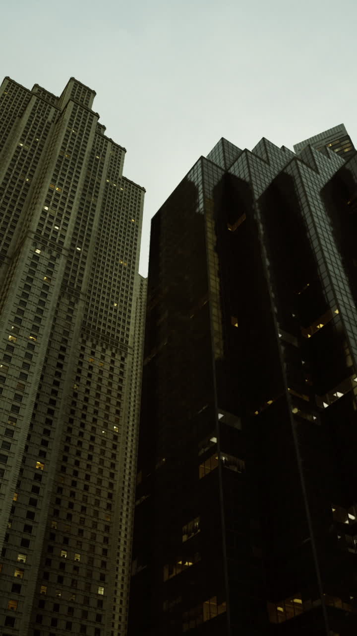Skyscrapers tower high above the city under a moody sky at dusk