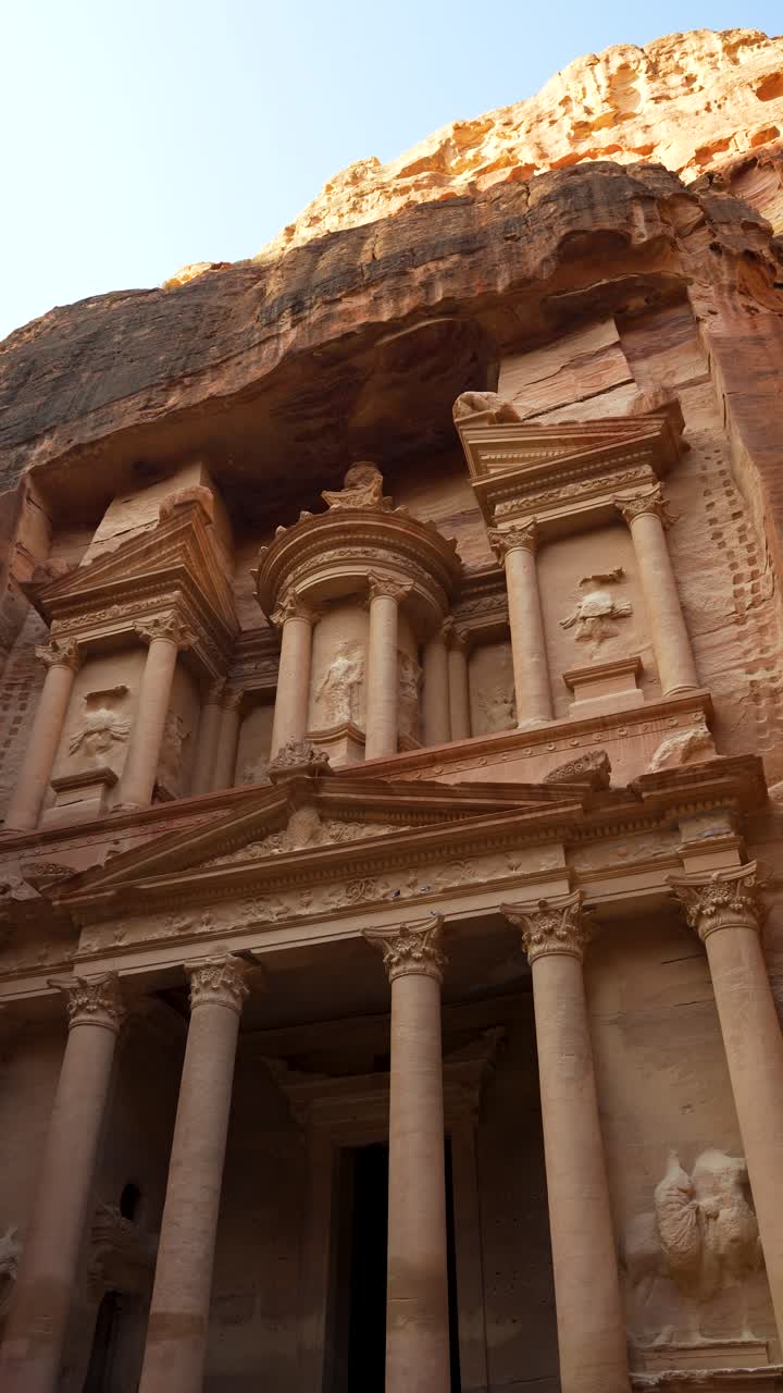 Ripresa verticale verso l'alto dell'incredibile facciata del Tesoro di Petra scolpita nella pietra arenaria.