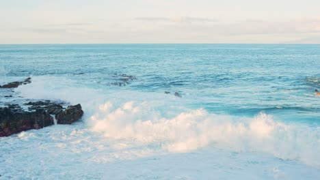 White-splashes-of-water-from-the-sea-towards-the-rocks-on-the-seashore-in-Tenerife,-Spain,-static-closeup-slow-motion