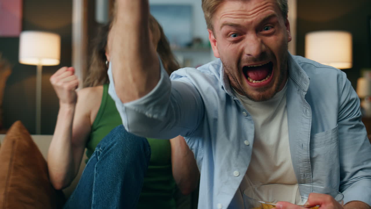 흥분 된 배우자 들 은 실내 축구 를 지지 하고 있다. 빈곤 한 부부 는 골 을 축하 하고 있다.