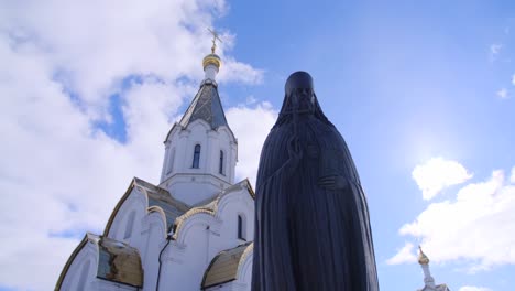 statue of a priest in front of a church