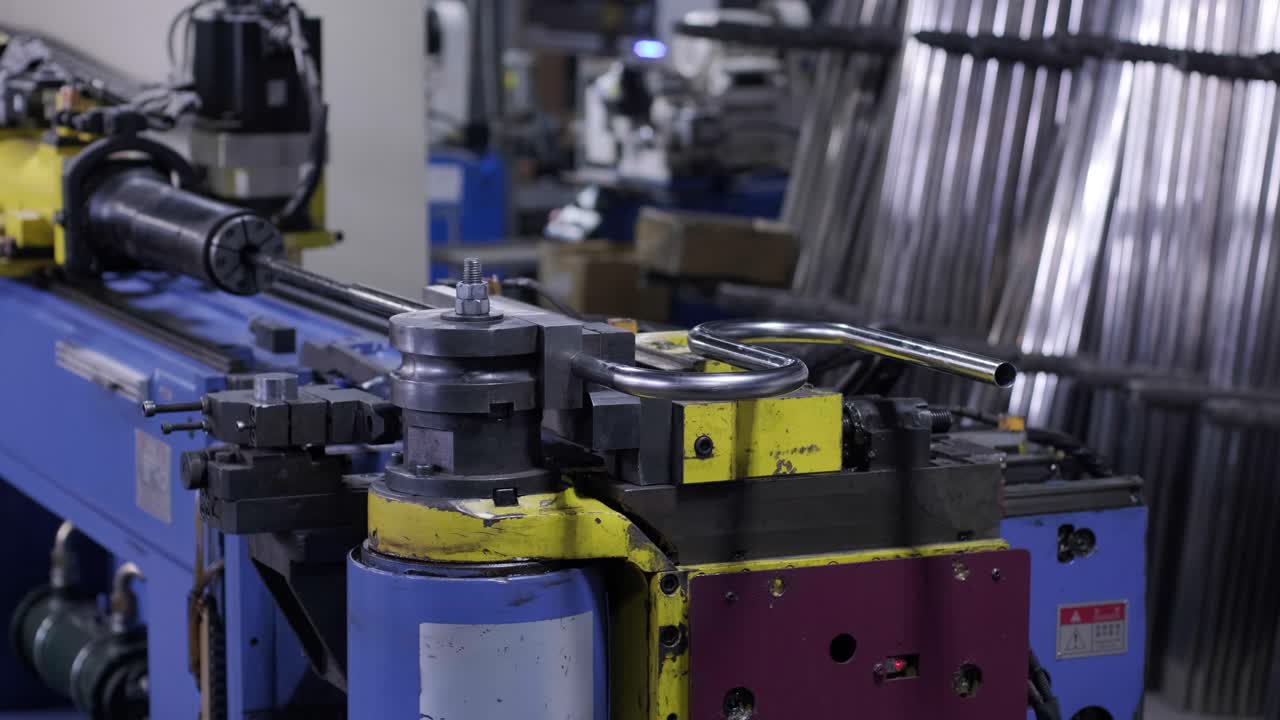 Industrial bender equipment machine for metal pipe bending in the factory. Automatic metalworking machine for electronic turning metal pipe and cold bending at industrial hall at manufacturing plant