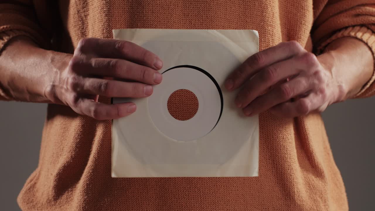 Retro Vinyl records in man hands close-up macro. Old disck for music. Retro vintage music player at home