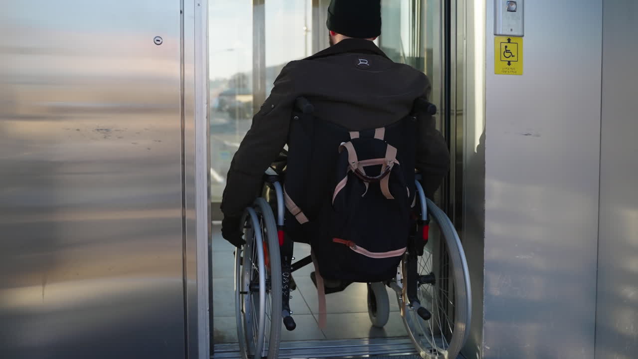 persona en silla de ruedas entrando en el ascensor