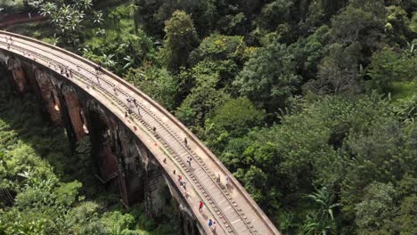 drone flying up over nine arch bridge in middle of jungle in sri lanka