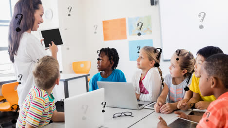 Animación-De-Signos-De-Interrogación-Sobre-Maestra-De-Escuela-Primaria-Y-Alumnos-Diversos-Con-Computadoras